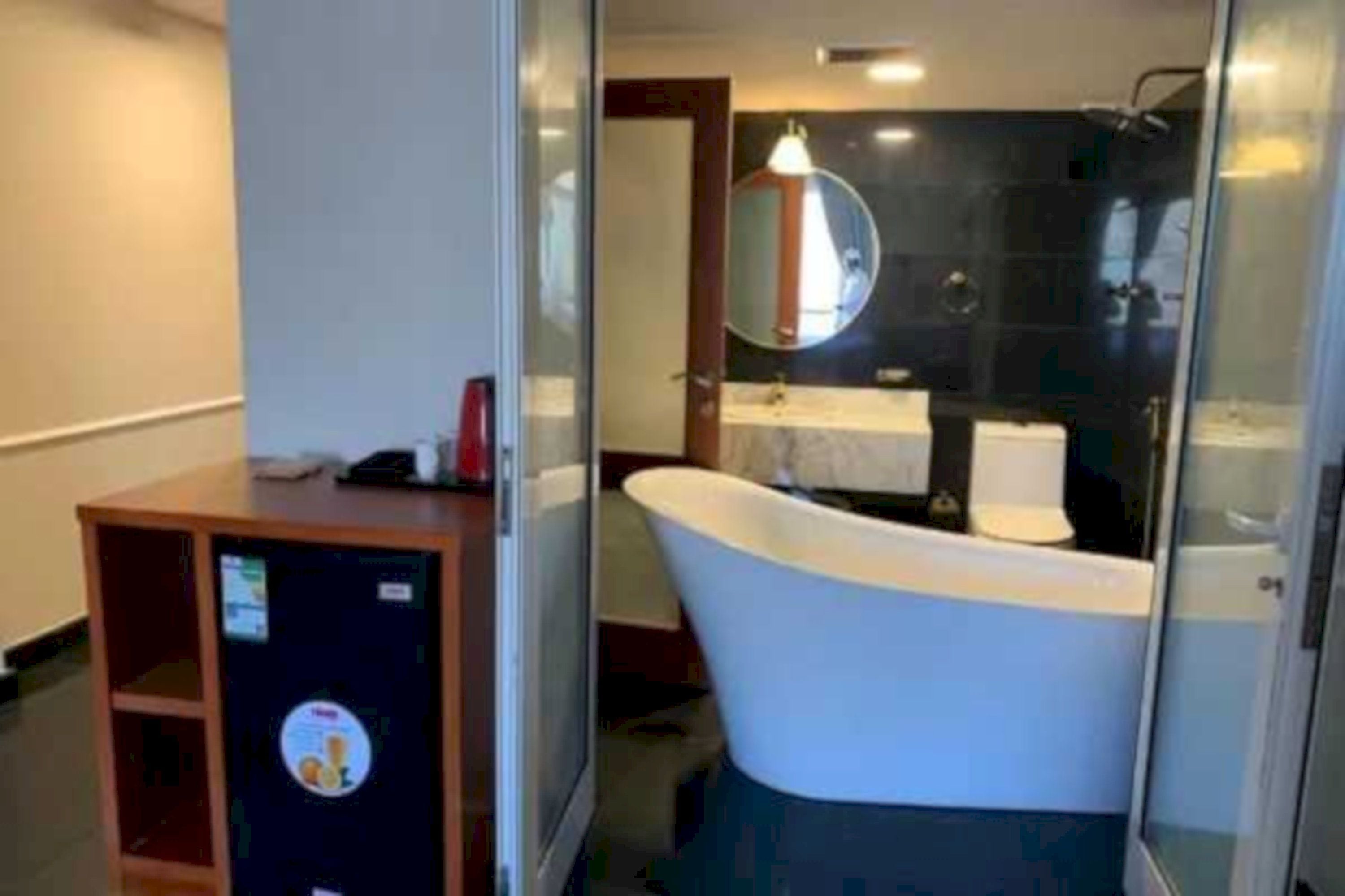 A bathroom with a freestanding bathtub, a mirror, and a sink.