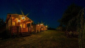 Una fila di casette di legno con finestre illuminate e un cielo stellato.