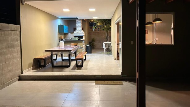 An open-plan living area with a kitchen, dining table, and benches.