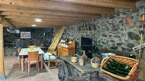 Un comedor rústico con pared de piedra, techo de madera y una mesa con sillas.