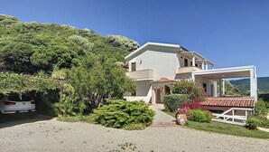 A two-story house with a covered porch and a gravel driveway. - Villa Surrounded by Nature Bbq Privacy Sea Relax (Castelsardo)