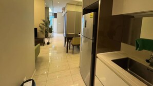 Une cuisine moderne équipée d’un réfrigérateur en acier inoxydable, d’un évier et d’un coin repas avec une table et des chaises.