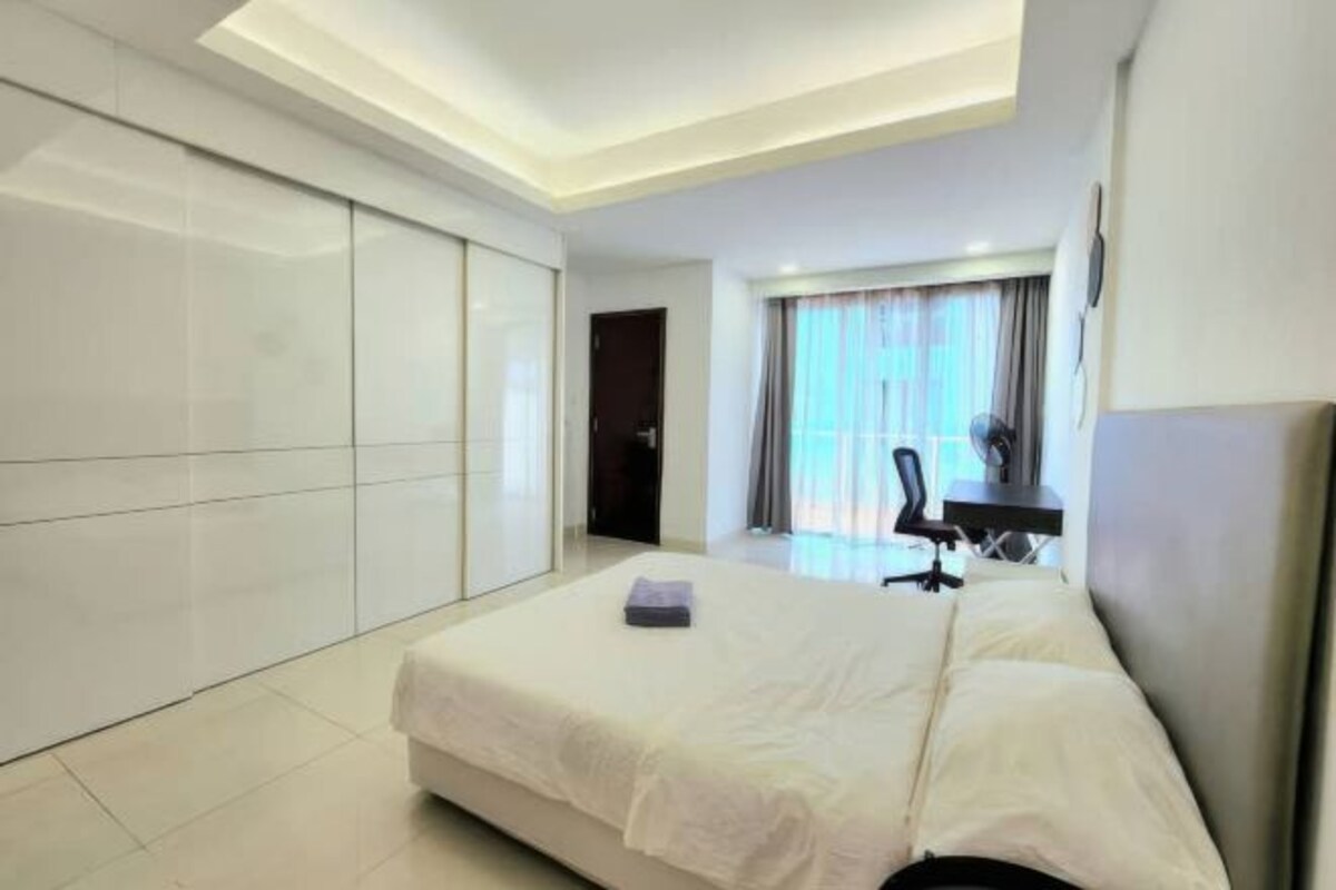 Una habitación de hotel moderna con una cama grande, un escritorio y una silla.