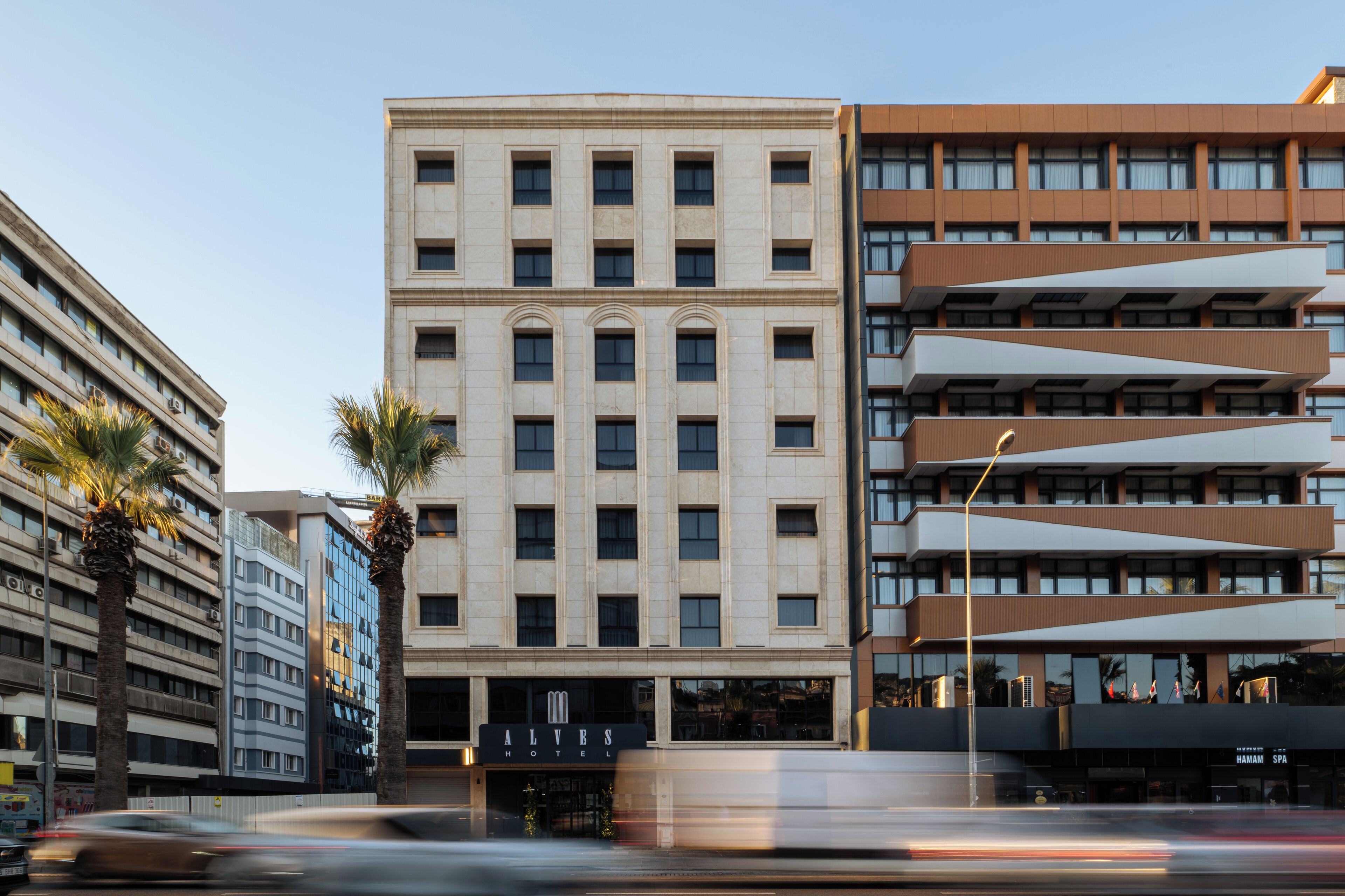 A hotel with a modern facade, multiple floors, and a prominent entrance.