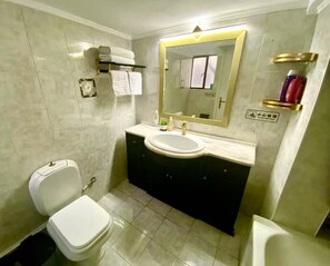 Een haardroger, handdoeken, zeep, toiletpapier