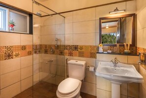 A bathroom with a toilet, shower, and sink.