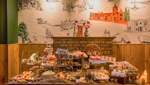 A buffet table with various food items and a mural in the background.