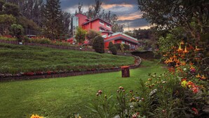 A red building with a garden in front.