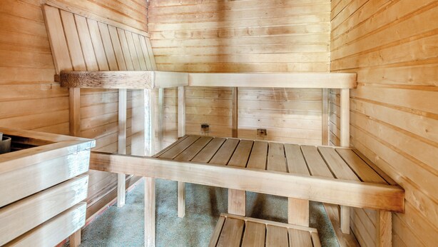 Eine Holzsauna mit Bänken und einer geneigten Decke.