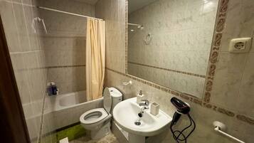 A bathroom with a toilet, sink, and bathtub.