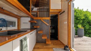 Une cuisine compacte avec des plans de travail en bois, une cuisinière intégrée et un petit évier.