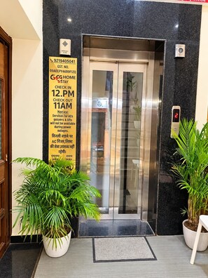 Entrada de ascensor con horario de registro/desocupación, alarma de emergencia y pantalla digital que muestra el número de piso.