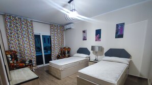 Une chambre avec deux lits, un canapé, un bureau et une chaise.