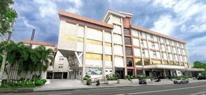Ein modernes Hotel mit einer markanten Eingangshalle, mehreren Etagen und einer Dachterrasse.