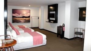 A hotel room with two beds, a painting of a landscape, a small table with a chair, and a desk with a chair. - Palette in Angeles, Pampanga near Clark International Airport (Formerly Boss Hotel) (Angeles City)