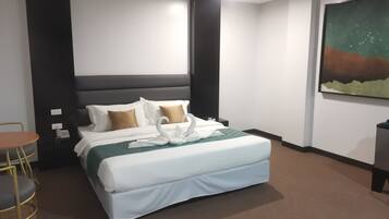 Una habitación de hotel con cama, una mesita y un cuadro en la pared.