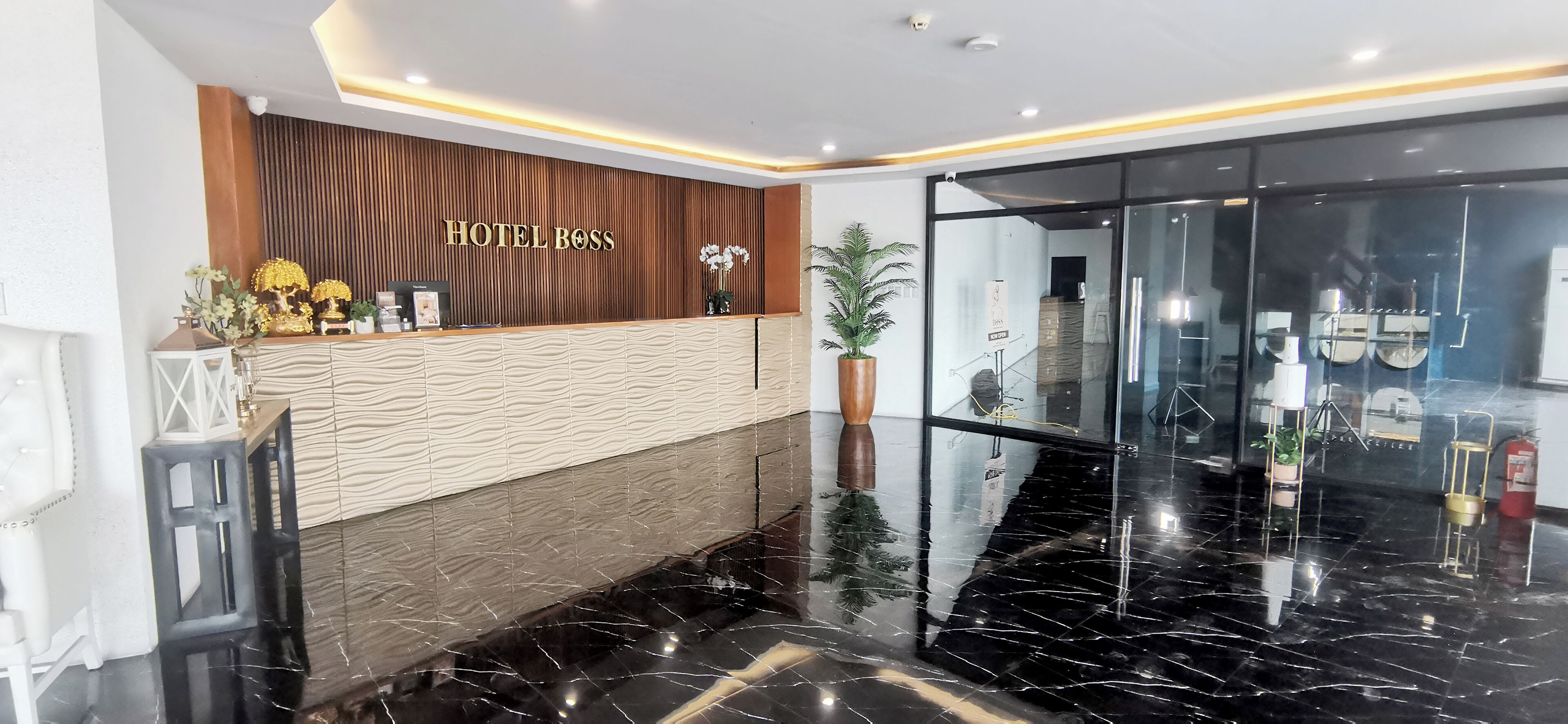 En hotelreception med en træpanel og et skilt der står 'HOTEL BOSS'.