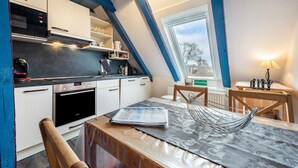 A kitchen with a built-in oven, microwave, and a window above the sink. - Apartment 'Kugelbake' with Shared Terrace, Communal Garden and Wi-Fi (Cuxhaven)