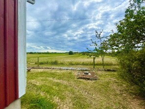 A rural landscape with a field, a fence, and a tree. - 4 Star Holiday Home in Kopingsvik (Kopingsvik)