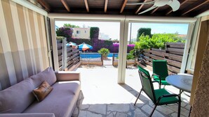 An outdoor patio area with a sofa, chairs, and a table. - Sophia Bay Home - a treasure box in Peyia (Pegeia)
