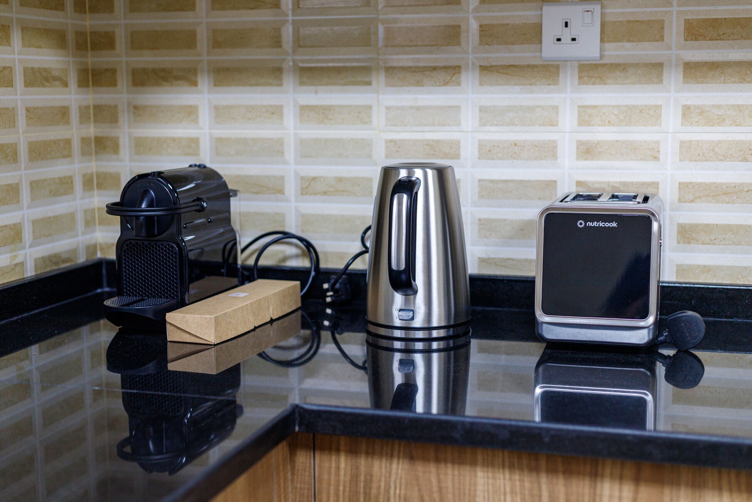 Un piano di lavoro in cucina con una moka, un tostapane e una scatola.