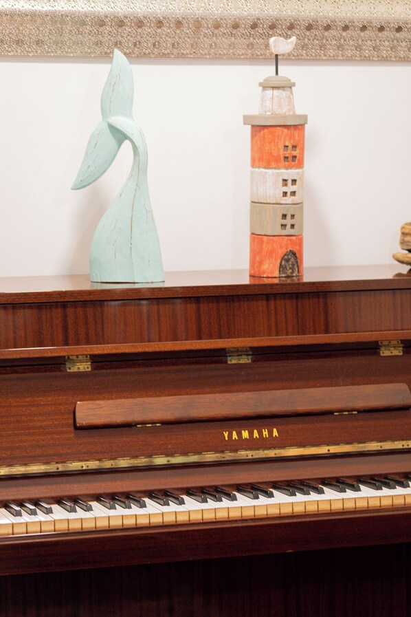 A Yamaha upright piano with a decorative item on top.