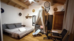 A bedroom with a bed, a desk, a chair, a ceiling fan, and a wardrobe.