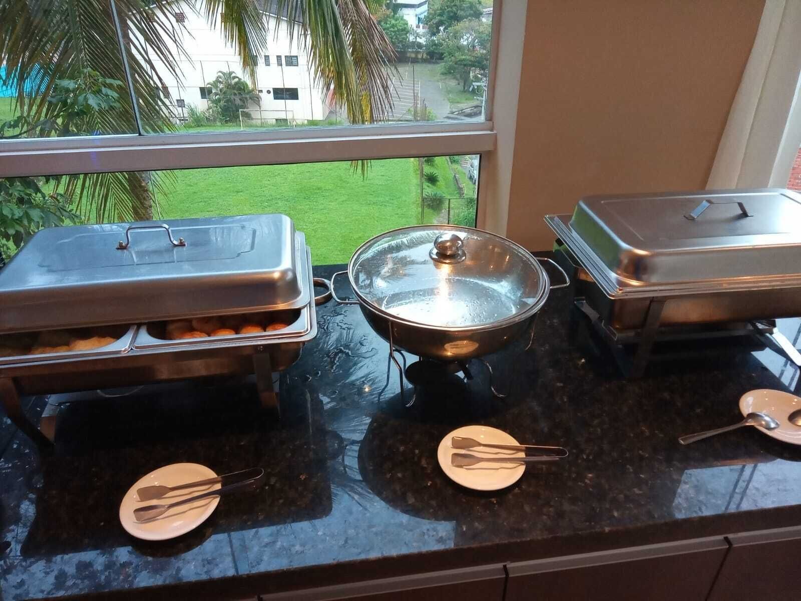 Una mesa de buffet con platos cubiertos y utensilios para servir.