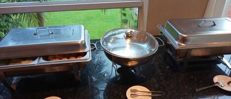 Una mesa de buffet con platos cubiertos y utensilios para servir.