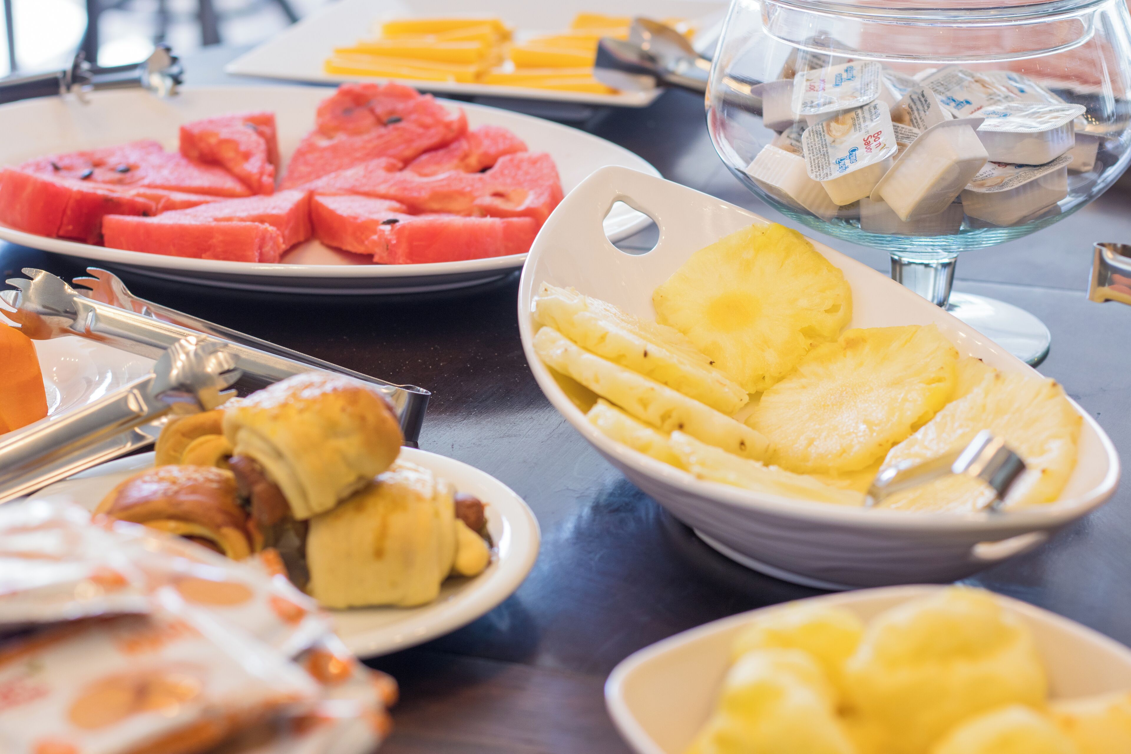 Een buffet met diverse gerechten, waaronder watermeloen, ananas en gebak.