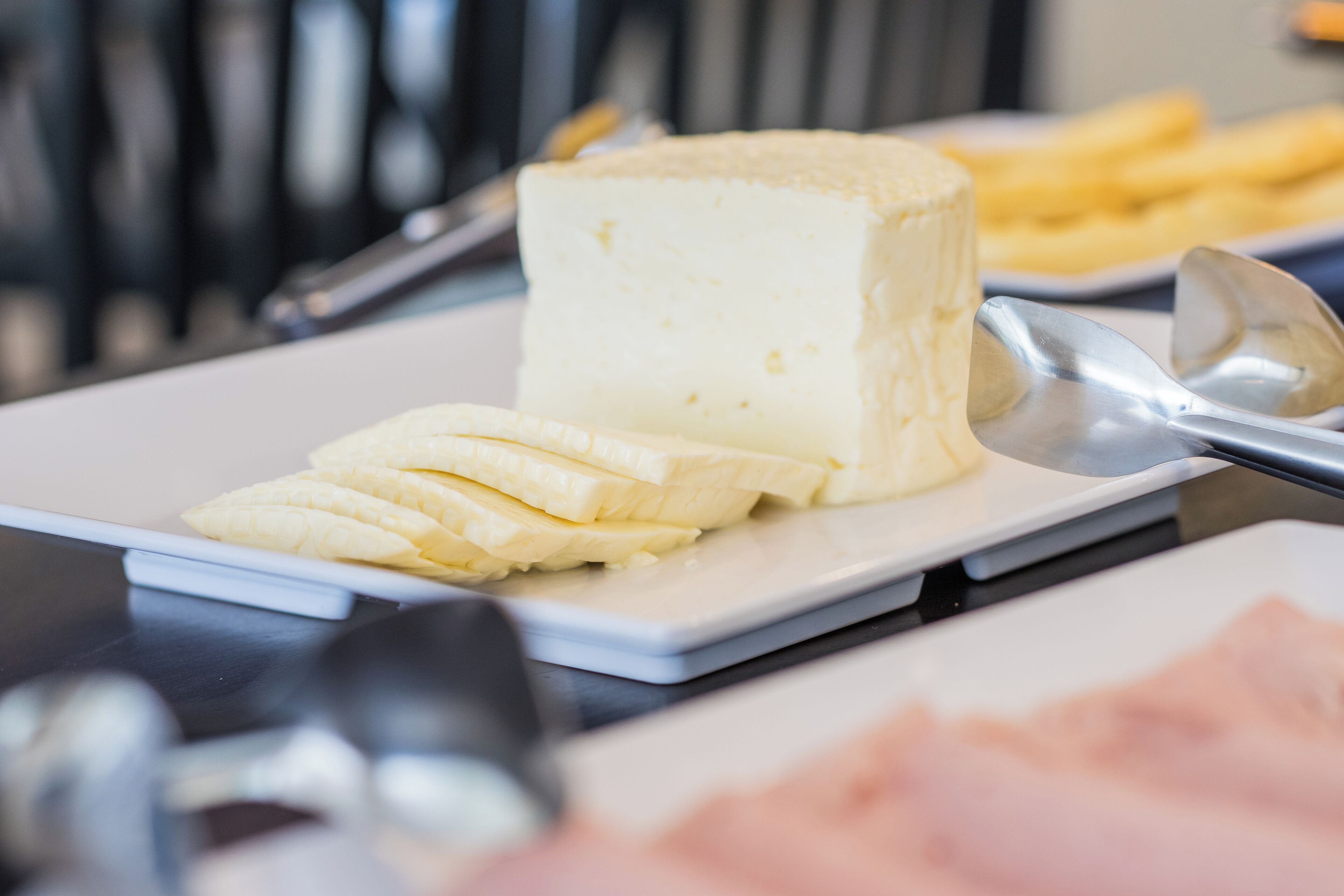 Un plato con queso y plátano sobre una bandeja blanca.