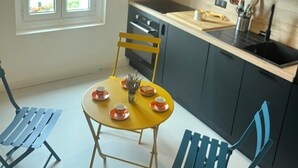 A compact kitchen with dark cabinets, a wooden countertop, and a small dining table with chairs. - Serenity and relaxation 3 km from the beach (Tarnos)