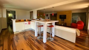 Een moderne keuken met een centraal eiland, barstoelen en een inbouwoven.