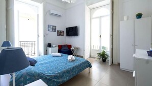 A bedroom with a bed, a TV, a desk, and a wardrobe. - Room Giulia By Dimorra (Napoli)