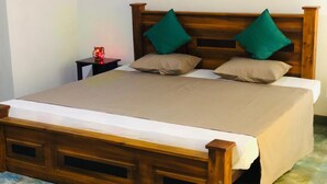 A wooden bed with a headboard, two green pillows, and a beige bedspread. - 3-bedroom house in Kandy City with WiFi, AC (kandy)