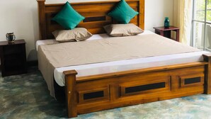A wooden bed with a headboard, two pillows, a bedside table, and a window with curtains. - 3-bedroom house in Kandy City with WiFi, AC (kandy)