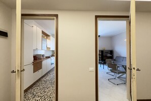 An open door leading to a kitchen with white cabinets, a microwave, and a dining area with a table and chairs. - 10 minutes from the Centre, Comfort and Culture (Bergamo)