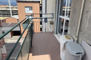 A balcony with a metal railing, a window, and a white trash bin. - 10 minutes from the Centre, Comfort and Culture (Bergamo)