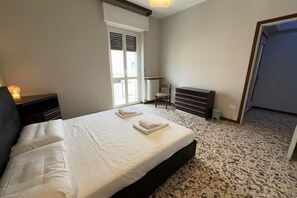 A bedroom with a bed, a radiator, a chair, and a window. - 10 minutes from the Centre, Comfort and Culture (Bergamo)