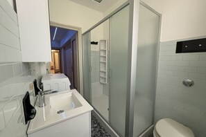 A bathroom with a white sink, a glass shower enclosure, and a toilet. - 10 minutes from the Centre, Comfort and Culture (Bergamo)
