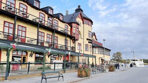 A multi-story building with balconies, a bar, and outdoor seating. - 4 Person Holiday Home in Vaxholm (Vaxholm)