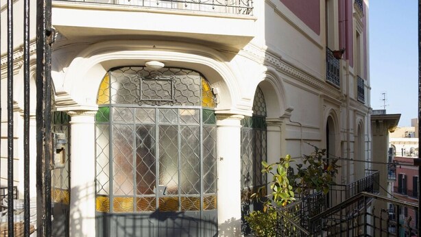 A building with a large glass door, a balcony with a railing, and a tiled floor. - At Giulia's Home Vomero Apt (NAPOLI)