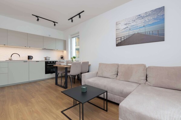 A modern apartment with a kitchen, dining area, and living room.