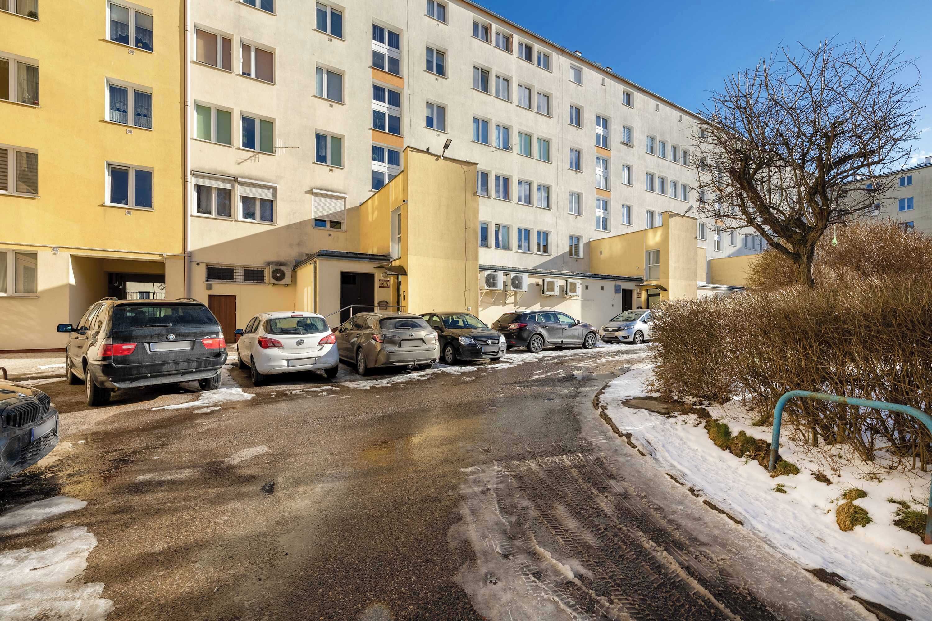 Useita kerroksia sisältävä pysäköintihalli, jossa on useita parkkeerattuja autoja.