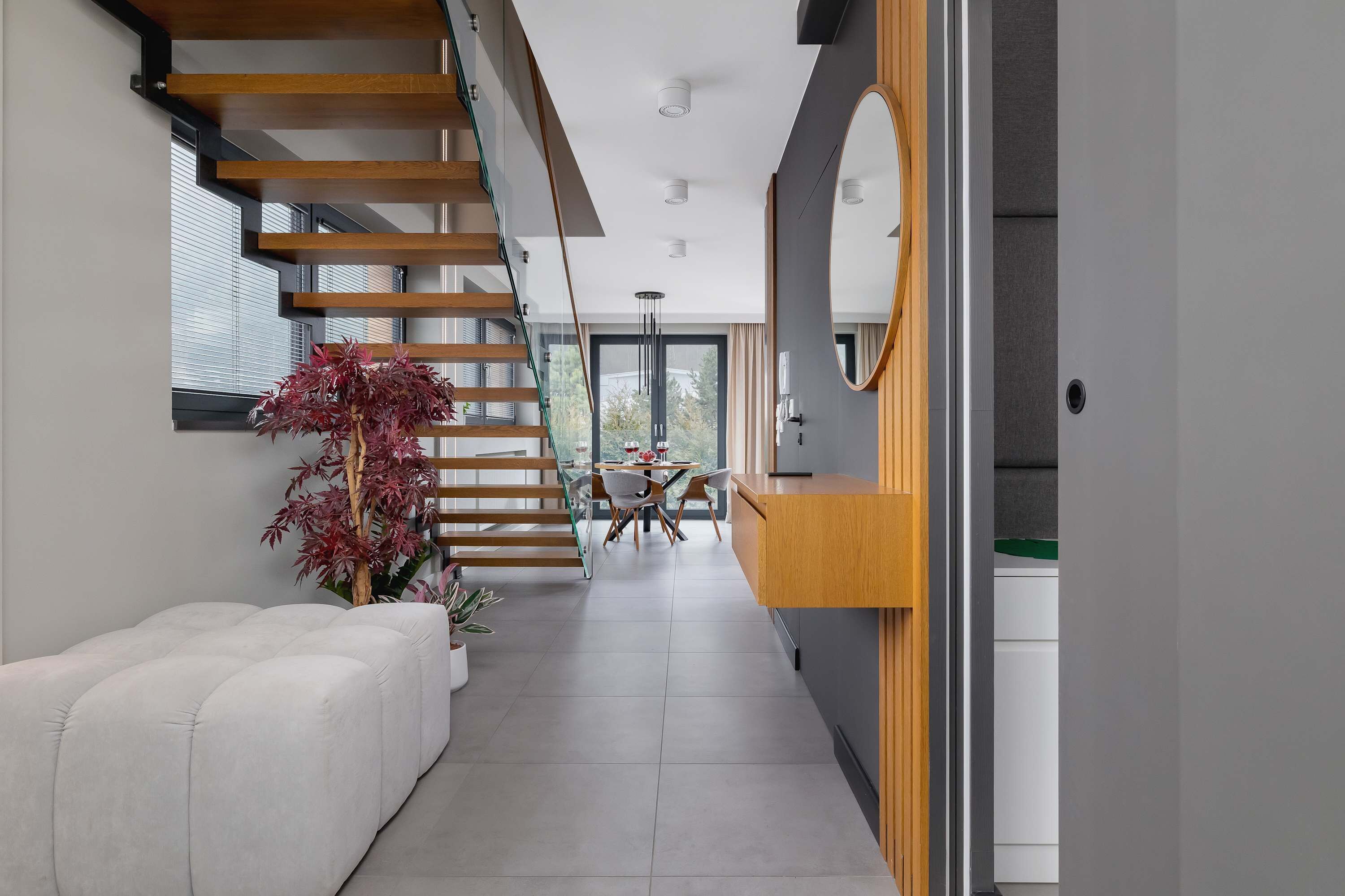 A modern interior with a staircase, a dining area, and a kitchen.