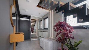 A modern interior with a mirrored wall, a wooden bench, and a potted plant. - Spacious Apartment | Balcony | Parking | Mountain View (Szczyrk)