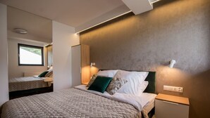 A modern bedroom with a large bed, bedside tables, and a window.