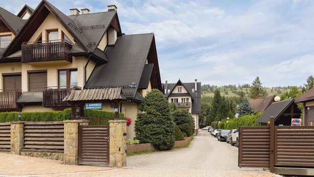 A residential area with houses, a paved driveway, and a gated entrance. - Family Apartment with Terrace | 2 km to Krupowki and Parking (Zakopane)