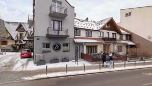 Un edificio de varios pisos con un balcón y un letrero con el logotipo 'M'.
