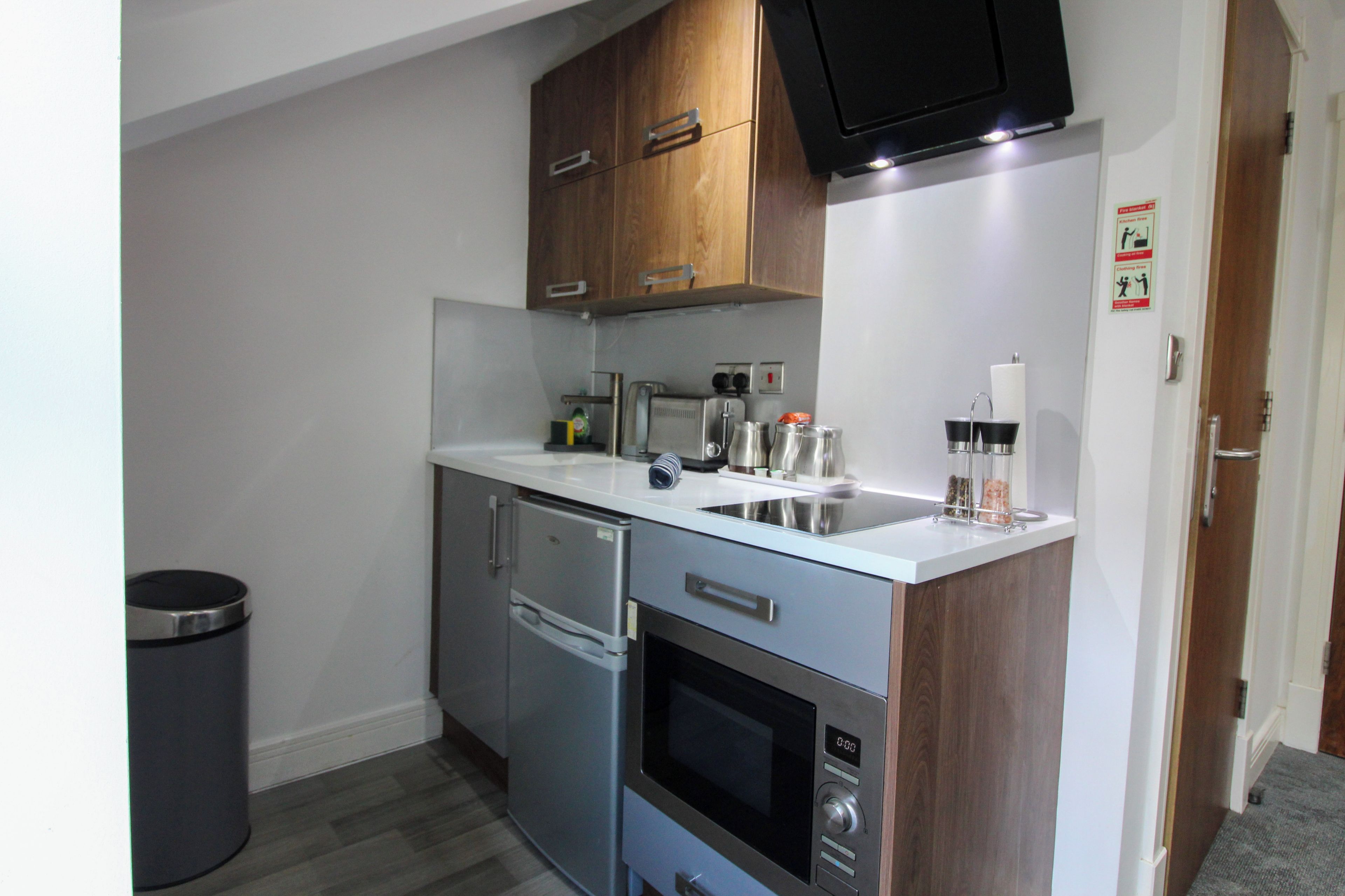 A compact kitchen with a built-in oven, a microwave, and a sink.